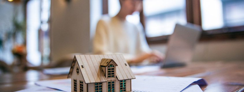 model home on table surrounded by files